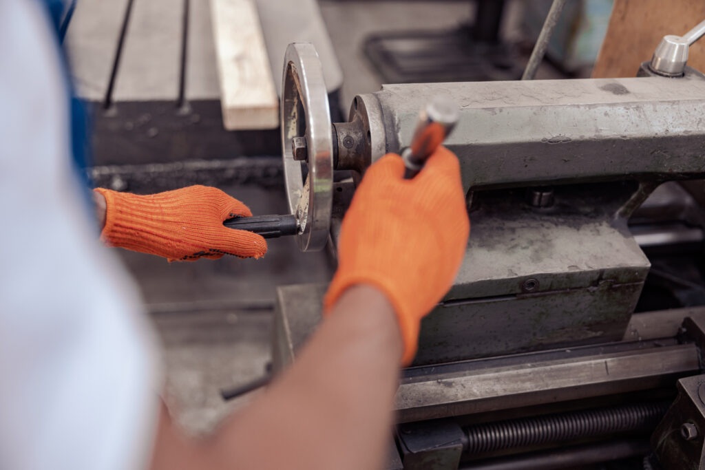 Notre entreprise 3 Gros plan sur un ouvrier du bâtiment portant des gants de travail, tenant des tournevis et utilisant du matériel industriel.